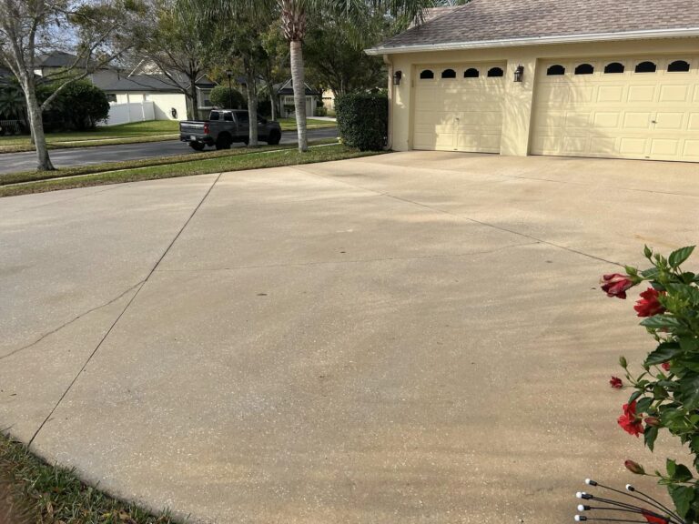 Driveway Cleaning 4 a driveway with a garage and cars in the background