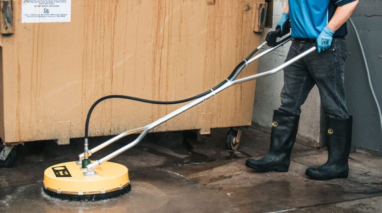 Dumpster Pad Cleaning 4 a person using a pressure washing to clean the floor