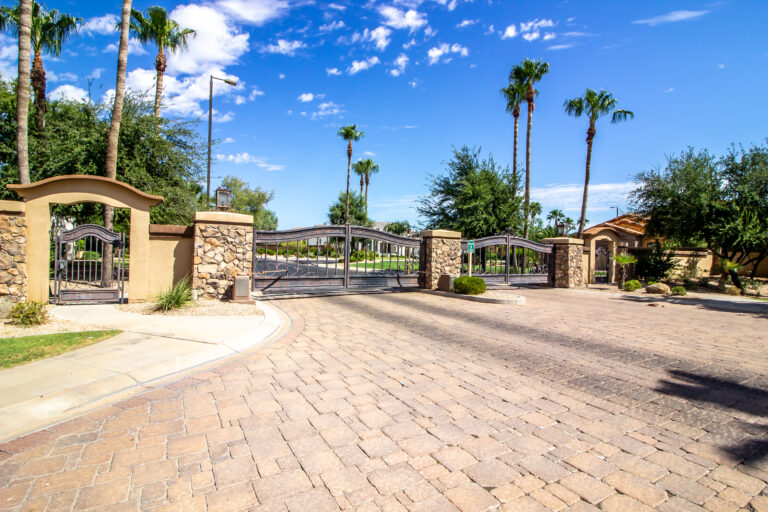 Cypress Gardens 14 a gated paver driveway with palm trees and a blue sky